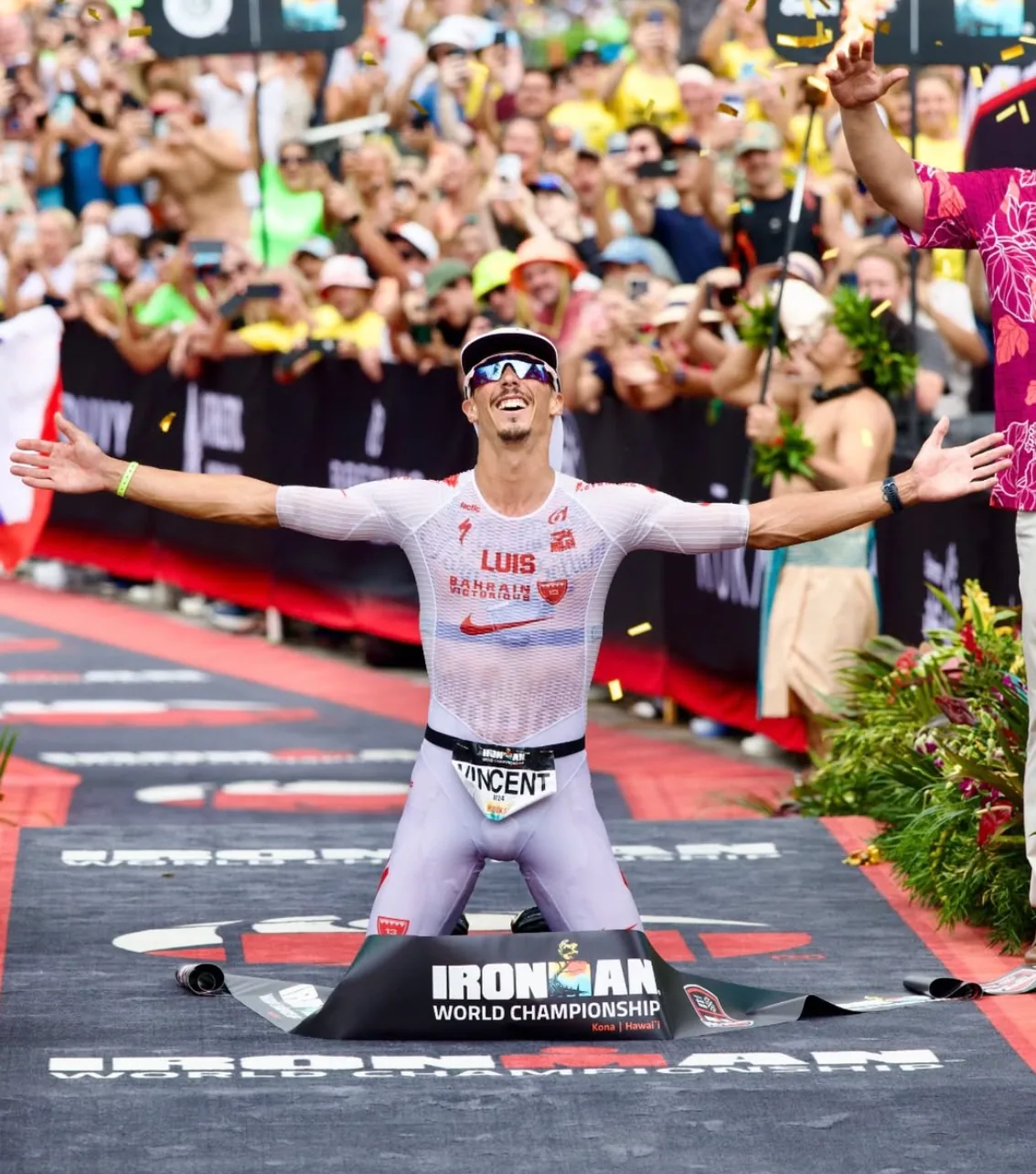 Vincent Luis kniet mit ausgebreiteten Armen im Ziel der Ironman-Weltmeisterschaft in Kona
